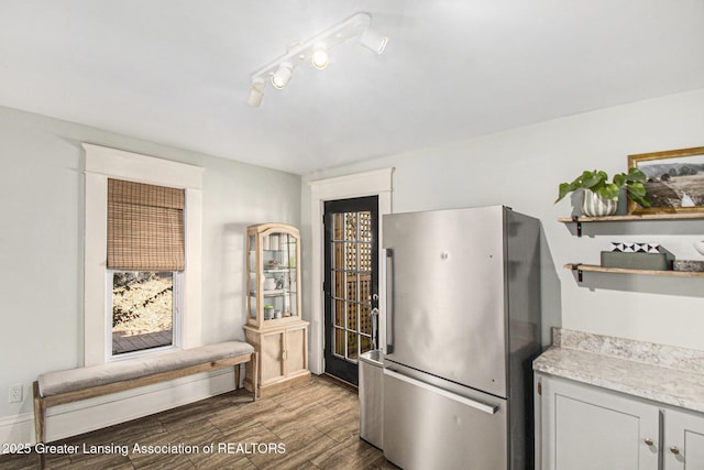 kitchen with open shelves, wood finished floors, light countertops, and freestanding refrigerator