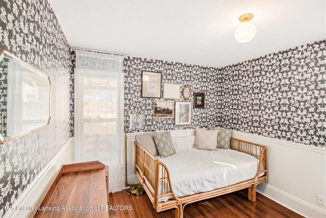 bedroom featuring multiple windows, wood finished floors, and wallpapered walls