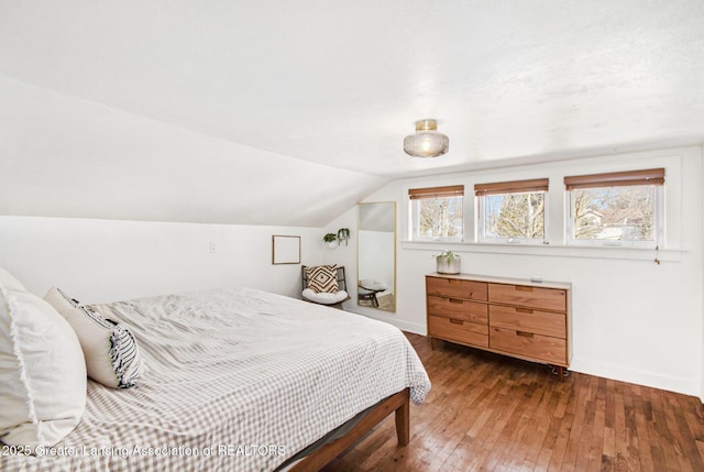 bedroom featuring vaulted ceiling, baseboards, and hardwood / wood-style flooring