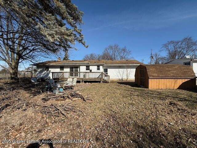 back of house featuring a storage shed, an outdoor structure, and a wooden deck