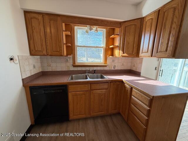 kitchen featuring dishwasher, open shelves, a peninsula, and a sink