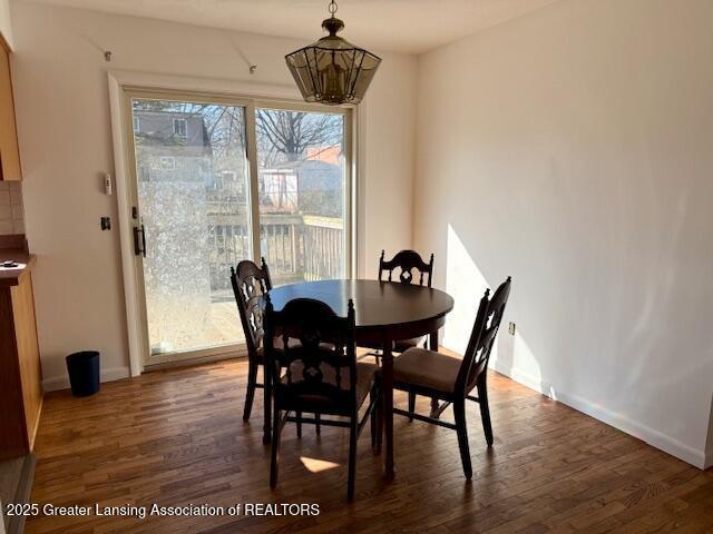 dining room featuring dark wood-type flooring and baseboards