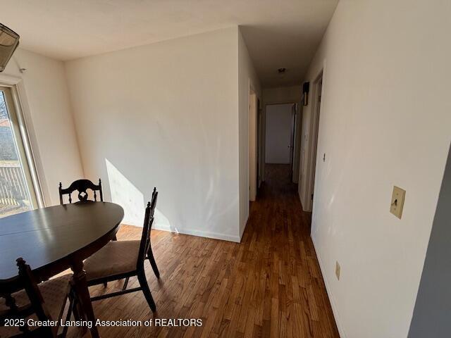 unfurnished dining area featuring wood finished floors and baseboards