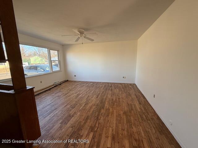 empty room with baseboards, ceiling fan, and wood finished floors