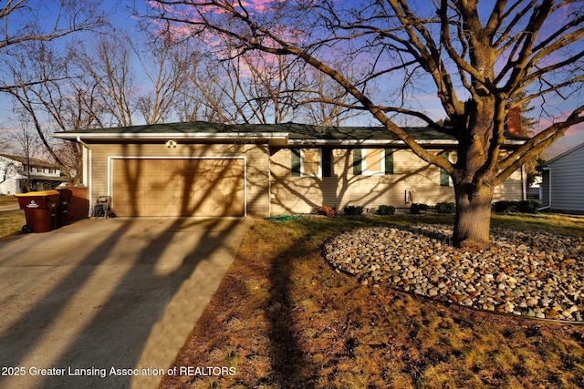 single story home with brick siding, a garage, and driveway