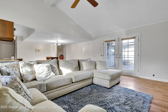 living area with high vaulted ceiling, a ceiling fan, wood finished floors, french doors, and baseboards