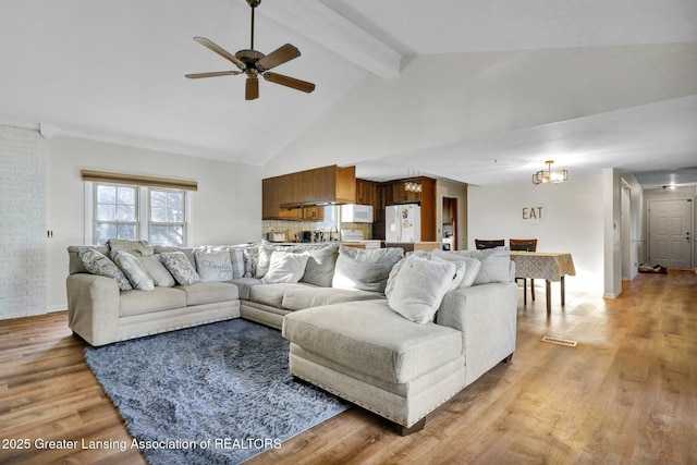 living area featuring visible vents, beamed ceiling, ceiling fan with notable chandelier, light wood-style floors, and high vaulted ceiling