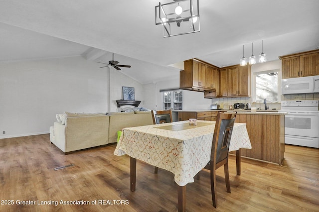 dining area with lofted ceiling with beams, light wood-style floors, visible vents, and ceiling fan