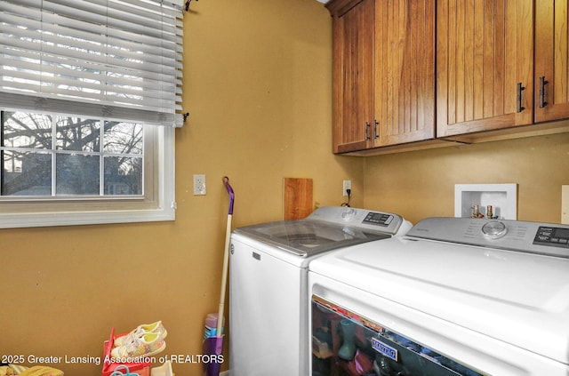 clothes washing area with washer and dryer and cabinet space