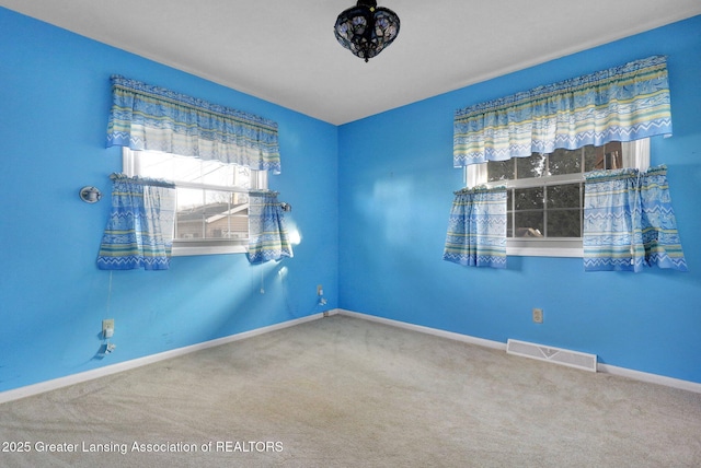 unfurnished room featuring baseboards, visible vents, and carpet floors