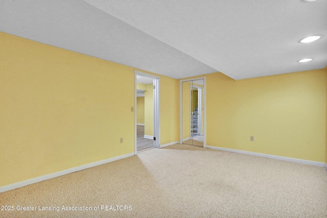 carpeted spare room featuring recessed lighting and baseboards