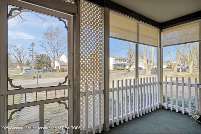 sunroom featuring a residential view and plenty of natural light