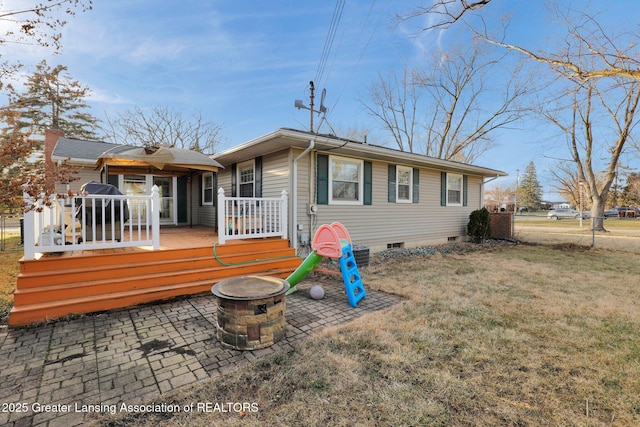 rear view of property with a lawn, a deck, fence, crawl space, and a patio area