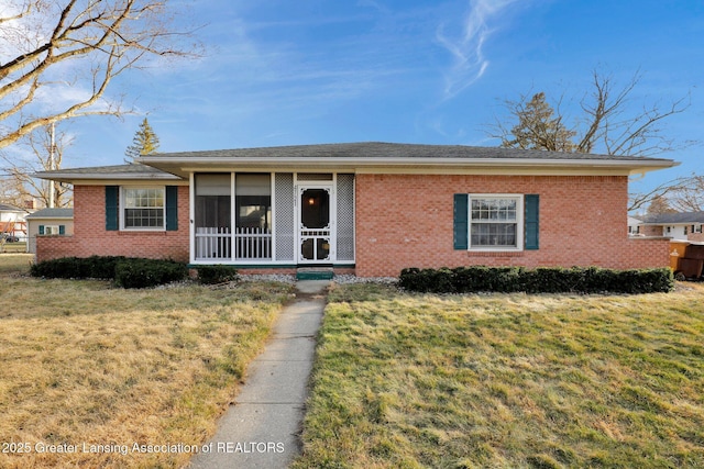 ranch-style home featuring brick siding and a front yard