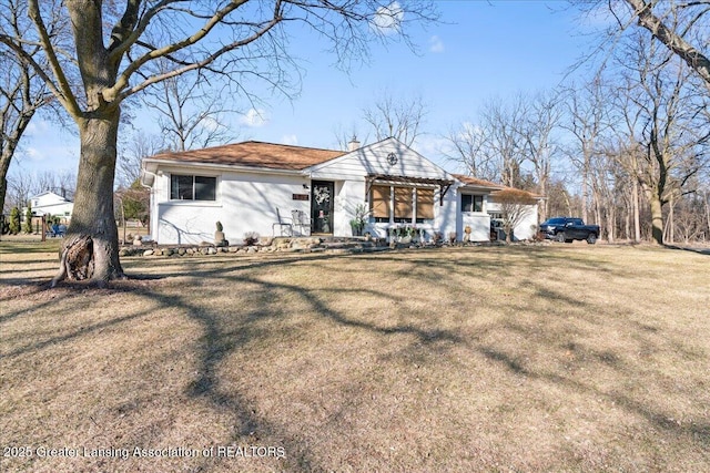 view of front facade with a front yard and a chimney