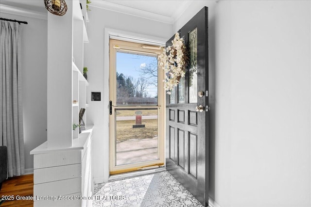 foyer entrance with crown molding and wood finished floors