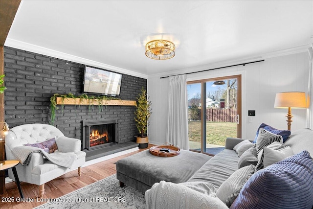 living area with a fireplace, wood finished floors, and ornamental molding