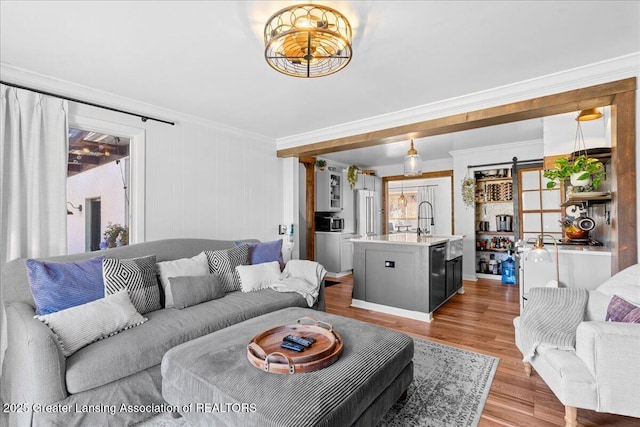 living room featuring light wood-style flooring and crown molding