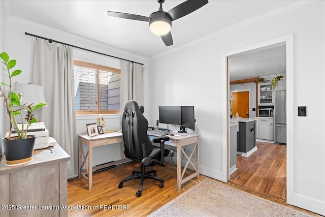 home office featuring light wood-style flooring, ceiling fan, and ornamental molding