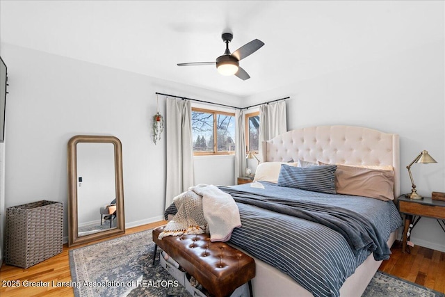 bedroom featuring ceiling fan, baseboards, and wood finished floors