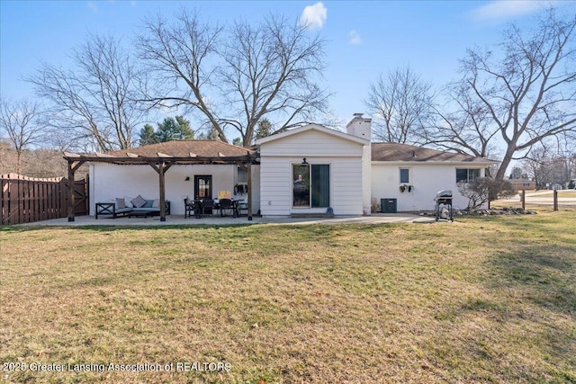 back of property with a lawn, a patio area, fence, and a chimney