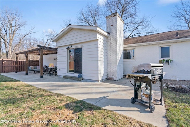 back of house featuring brick siding, fence, a chimney, a patio area, and a pergola