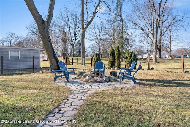 view of yard with a fire pit and fence