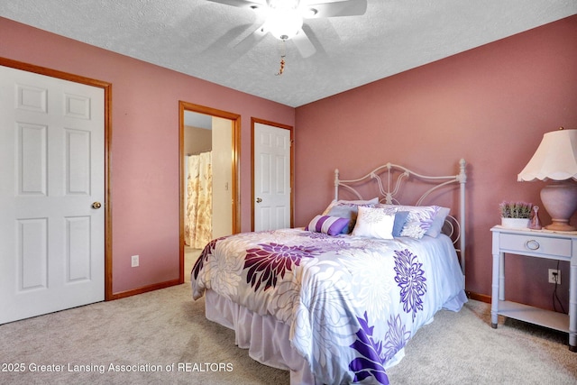 carpeted bedroom featuring baseboards, a textured ceiling, and a ceiling fan