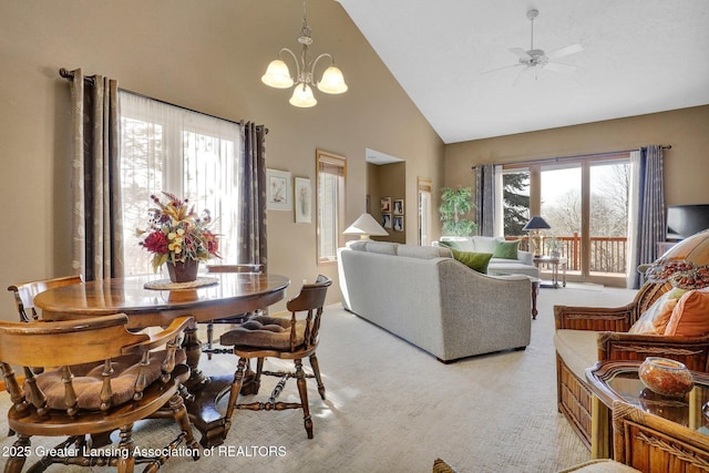 living area featuring light carpet, ceiling fan with notable chandelier, and high vaulted ceiling