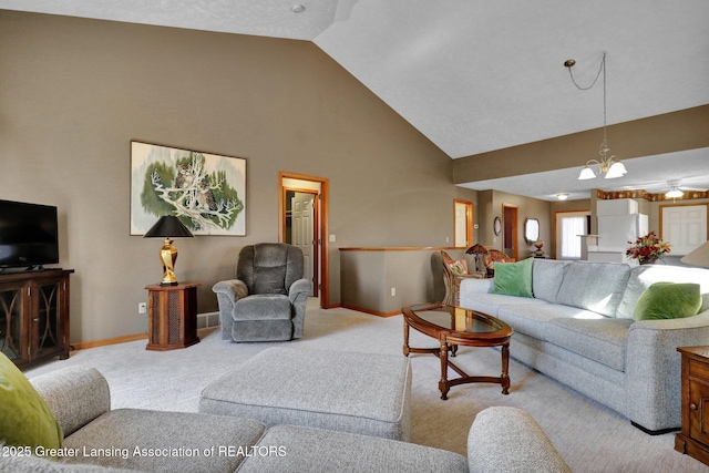 carpeted living room featuring a notable chandelier, high vaulted ceiling, and baseboards