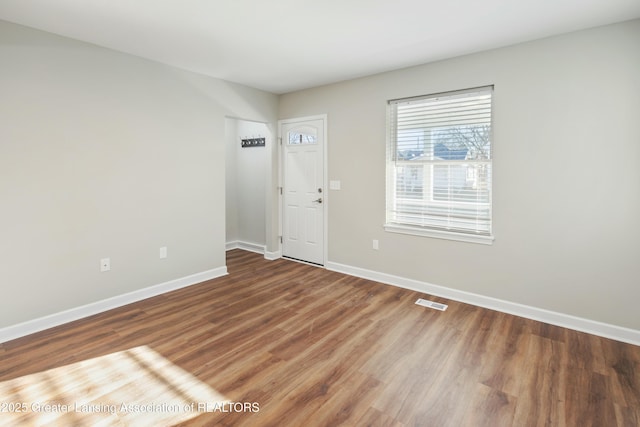 entryway featuring visible vents, baseboards, and wood finished floors