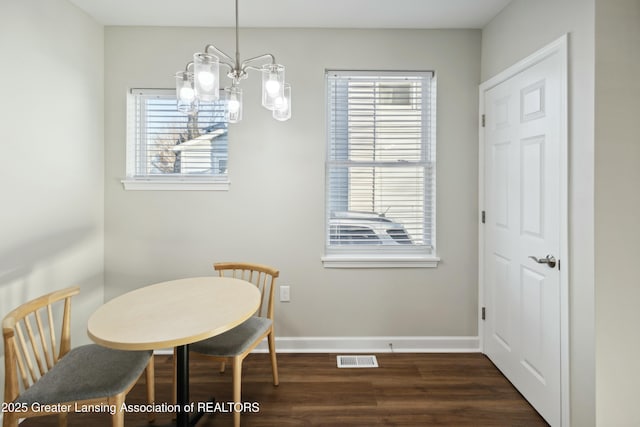 dining space featuring visible vents, a notable chandelier, dark wood-style floors, and baseboards