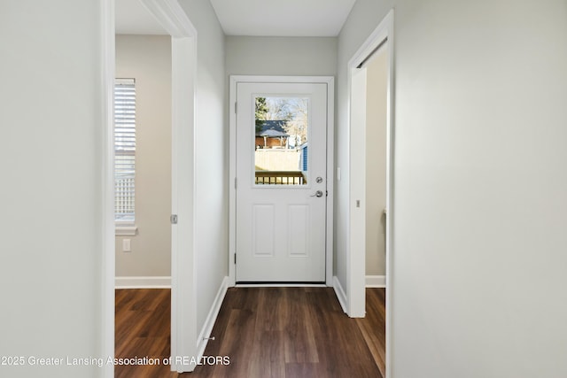 doorway to outside featuring baseboards and dark wood-style flooring