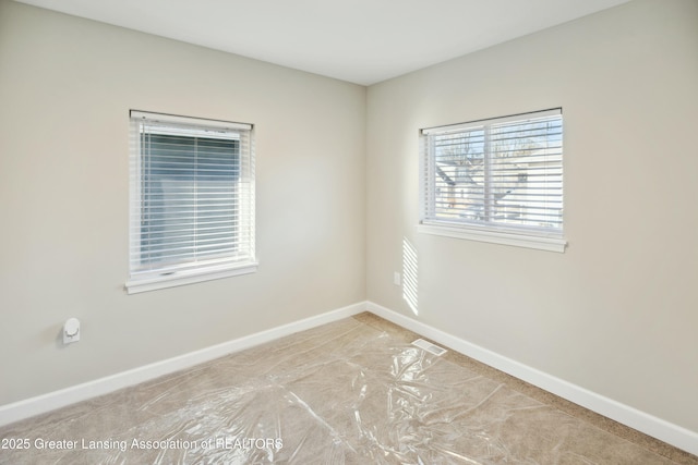 unfurnished room featuring visible vents and baseboards