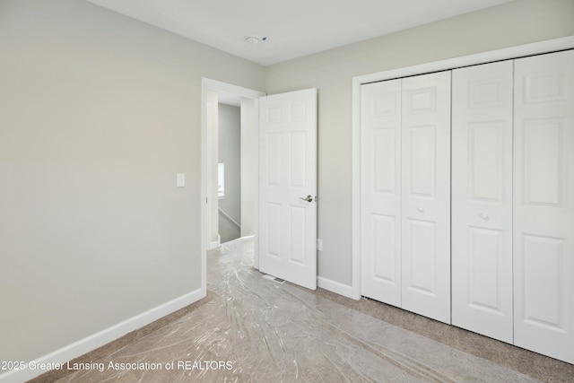 unfurnished bedroom with a closet and baseboards