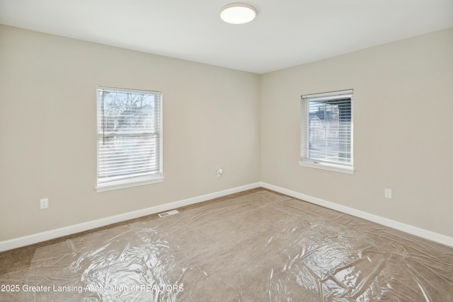 spare room featuring visible vents and baseboards