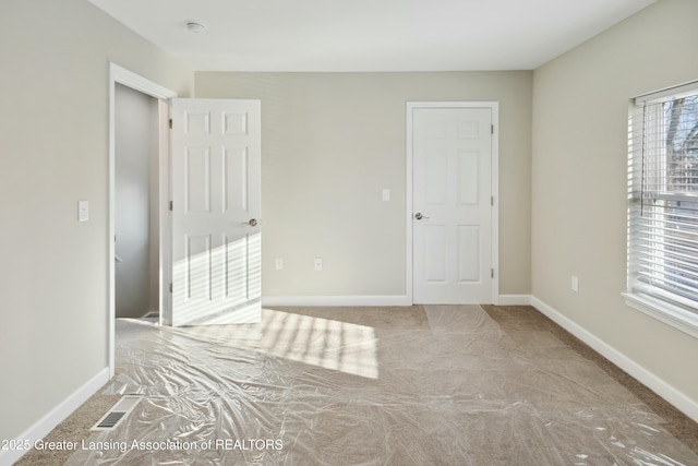 unfurnished bedroom with visible vents and baseboards