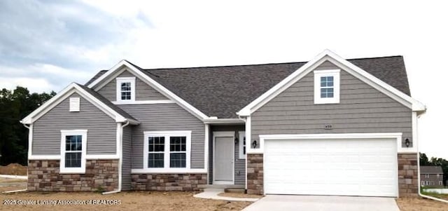 craftsman-style home featuring stone siding, concrete driveway, and a garage