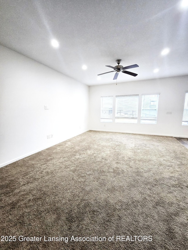 unfurnished living room featuring ceiling fan, carpet, a wealth of natural light, and a textured ceiling