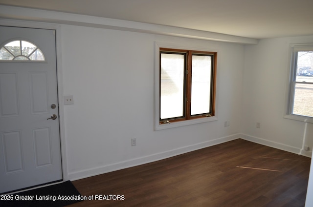 foyer with dark wood-type flooring and baseboards