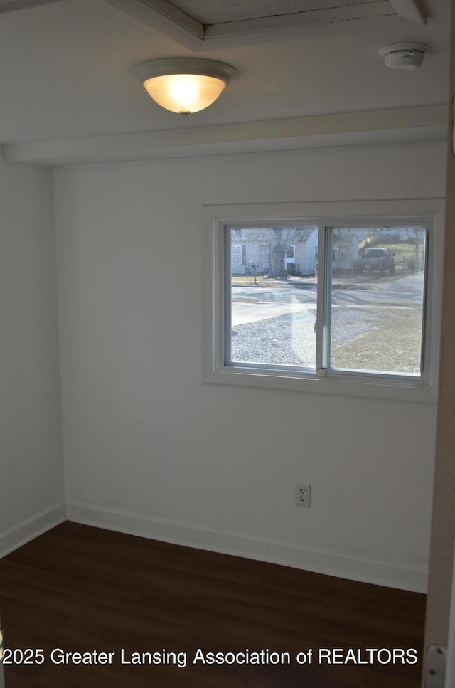 unfurnished room with dark wood finished floors, a healthy amount of sunlight, and baseboards