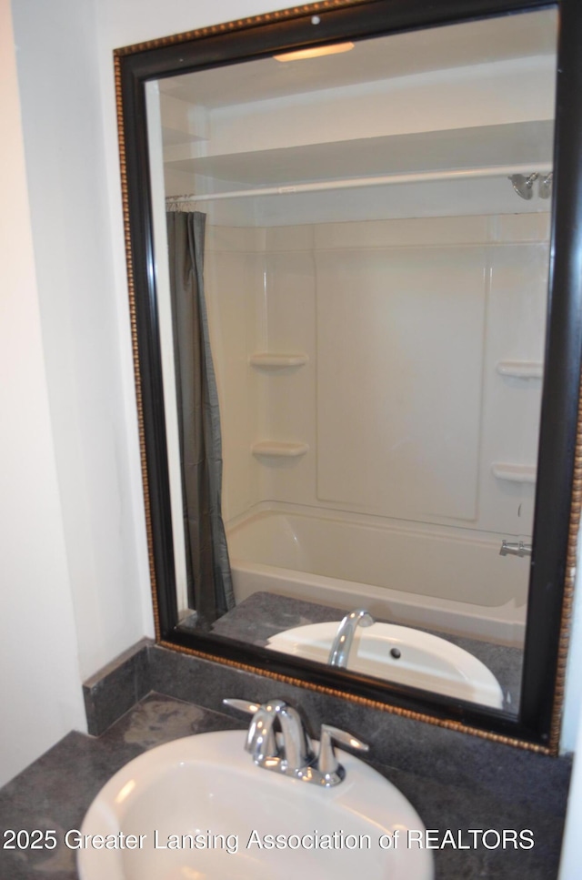 bathroom with a sink and shower / bathtub combination with curtain