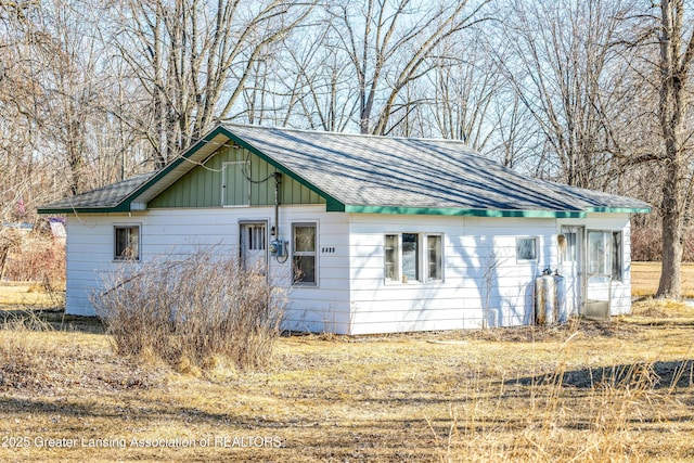 view of property exterior with board and batten siding and a shingled roof