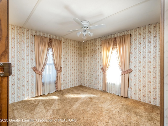 spare room featuring ceiling fan, wallpapered walls, and carpet