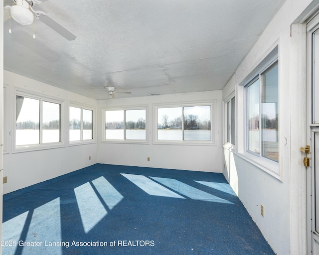 unfurnished sunroom with ceiling fan