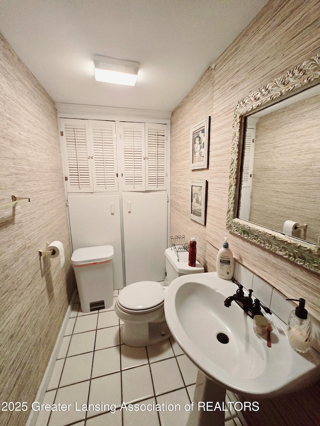 bathroom with tile patterned floors, toilet, and a sink