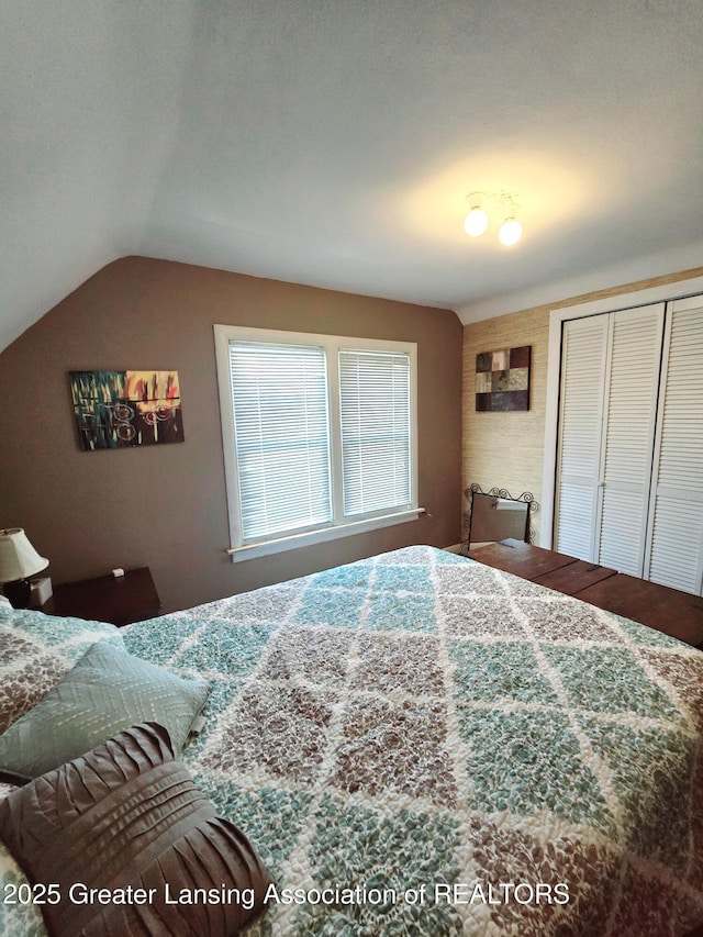 bedroom with vaulted ceiling and a closet