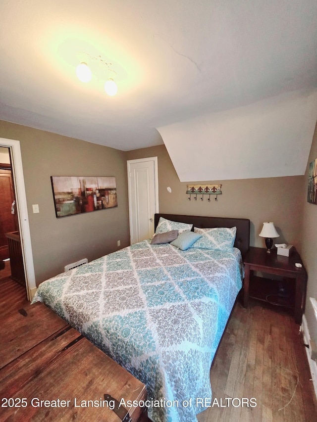 bedroom with lofted ceiling and wood finished floors