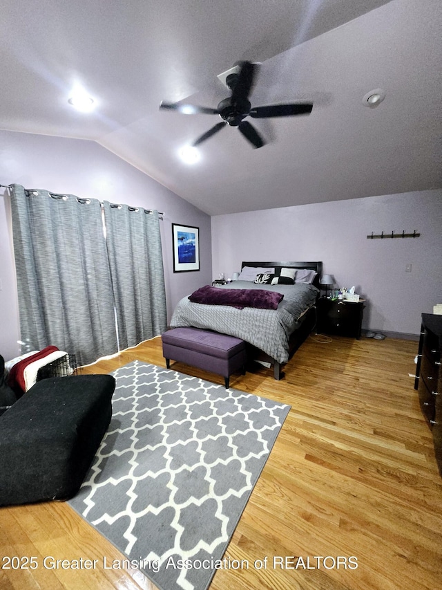 bedroom with a ceiling fan, lofted ceiling, and wood finished floors