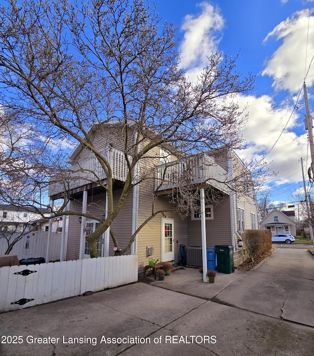 exterior space with a fenced front yard and central AC unit